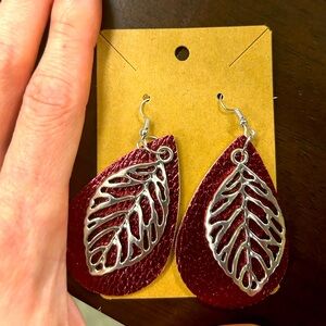 Metal alloy large leaf earrings with leather backing.